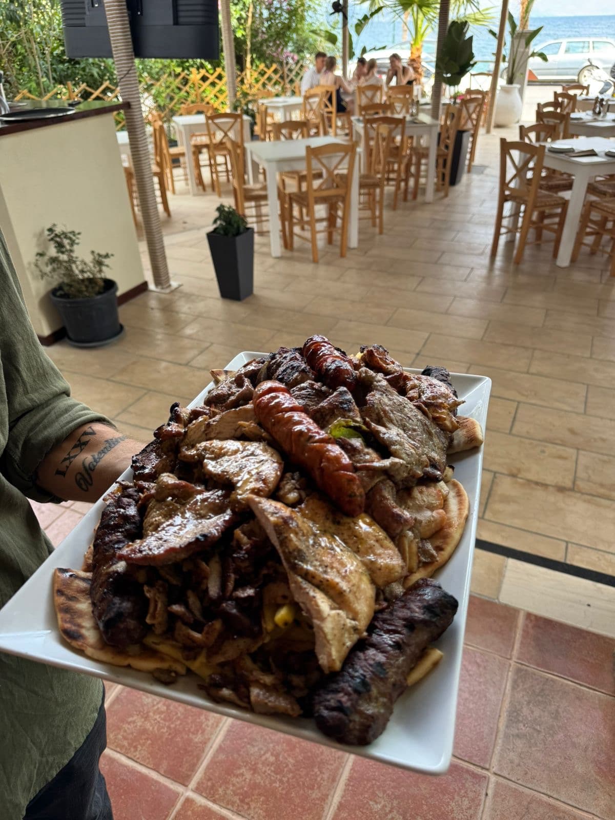 Mixed grill platter served on the terrace with the sea behind